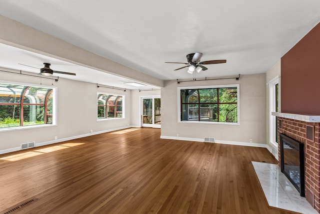 600 W Bloomingdale Rd, Itasca, IL 60143 - unfurnished living room featuring ceiling fan, a brick fireplace, wood finished floors, and healthy amount of natural light