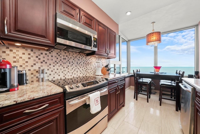 1300 N Lake Shore Dr Unit 10B, Chicago, IL 60610 - kitchen featuring stainless steel appliances, tasteful backsplash, hanging light fixtures, and light stone counters