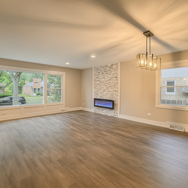 18506 Martin Ave, Homewood, IL 60430 - unfurnished living room featuring a chandelier, a stone fireplace, dark wood-style floors, and recessed lighting