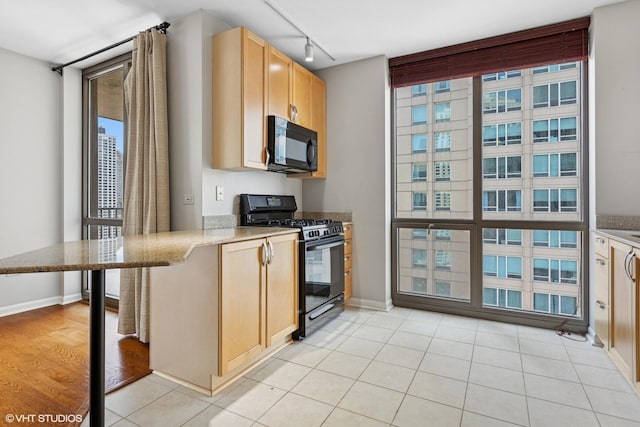 635 N Dearborn St Unit 2506, Chicago, IL 60654 - kitchen featuring black appliances, light brown cabinets, track lighting, light stone countertops, and light tile patterned floors