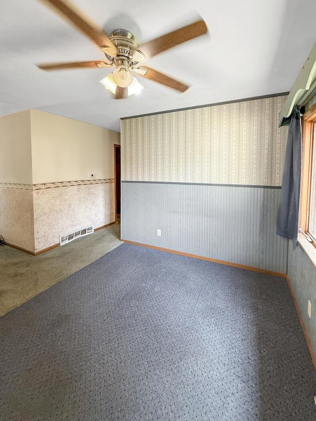 207 Southview Dr, Rochelle, IL 61068 - unfurnished room with wallpapered walls, a ceiling fan, and wainscoting