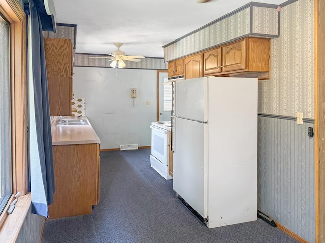 207 Southview Dr, Rochelle, IL 61068 - kitchen with white appliances, wallpapered walls, a ceiling fan, light countertops, and dark carpet