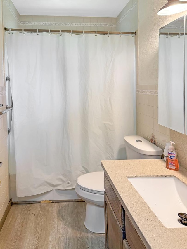 207 Southview Dr, Rochelle, IL 61068 - full bathroom featuring vanity, wood finished floors, tile walls, and curtained shower