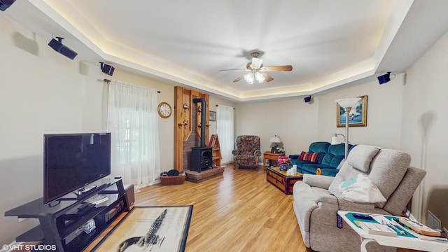 1513 Berwyn St, Spring Grove, IL 60081 - living room with a tray ceiling, a wood stove, light wood finished floors, and a ceiling fan