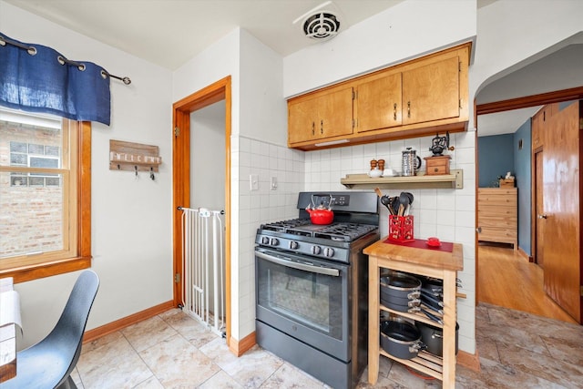 3820 Lombard Ave, Berwyn, IL 60402 - kitchen featuring stainless steel range with gas stovetop, brown cabinetry, and decorative backsplash