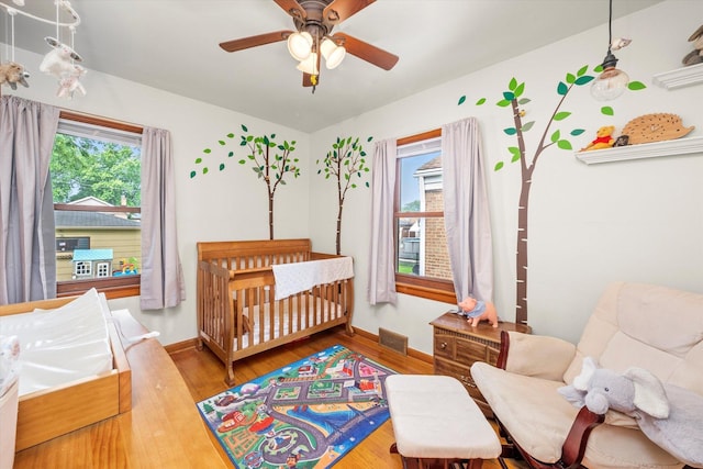 3820 Lombard Ave, Berwyn, IL 60402 - bedroom with multiple windows, a nursery area, wood finished floors, and ceiling fan