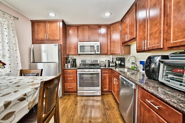 9666 Lois Dr Unit D, Des Plaines, IL 60016 - kitchen featuring stainless steel appliances, dark wood-style floors, dark stone countertops, recessed lighting, and tasteful backsplash