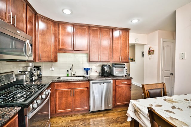 9666 Lois Dr Unit D, Des Plaines, IL 60016 - kitchen featuring stainless steel appliances, dark wood-type flooring, dark stone counters, decorative backsplash, and recessed lighting
