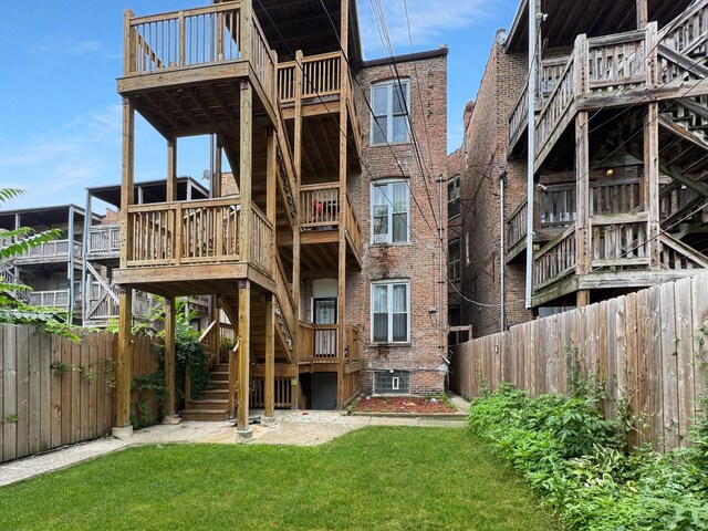 5943 S Indiana Ave, Chicago, IL 60637 - rear view of property featuring stairway, brick siding, and a fenced backyard