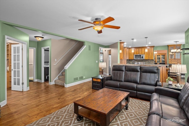 24209 Lavergne St, Plainfield, IL 60585 - living room with wood finished floors, a ceiling fan, stairs, and recessed lighting