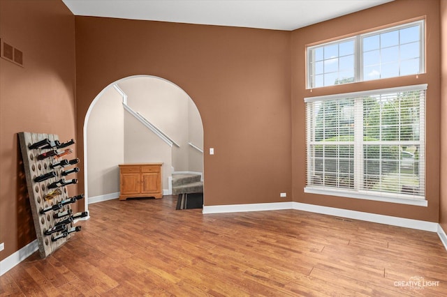 24209 Lavergne St, Plainfield, IL 60585 - empty room with arched walkways, light wood-style flooring, and stairs
