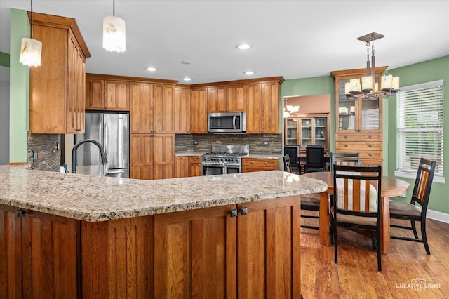 24209 Lavergne St, Plainfield, IL 60585 - kitchen featuring stainless steel appliances, brown cabinets, light wood-style floors, tasteful backsplash, and recessed lighting