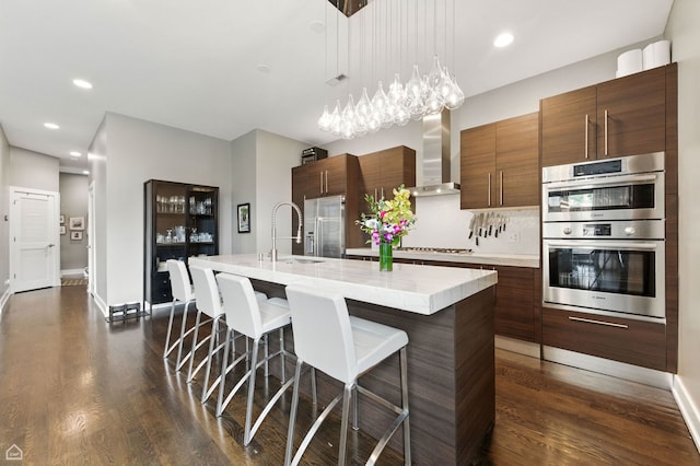 1312 W Madison St Unit 3A, Chicago, IL 60607 - kitchen featuring wall chimney exhaust hood, stainless steel appliances, light countertops, dark wood finished floors, and recessed lighting