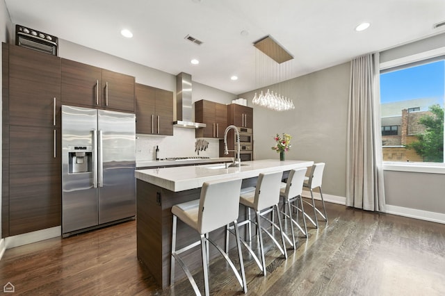 1312 W Madison St Unit 3A, Chicago, IL 60607 - kitchen featuring high end fridge, wall chimney range hood, dark wood-style flooring, light countertops, and recessed lighting