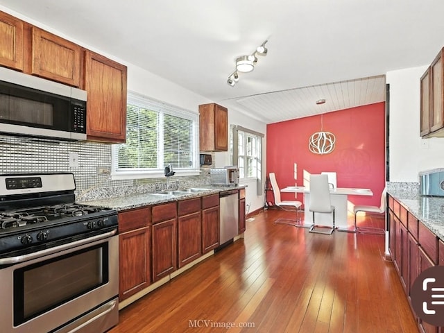 216 Cheshire Ct, Bolingbrook, IL 60440 - kitchen featuring stainless steel appliances, dark wood-style floors, light stone countertops, pendant lighting, and decorative backsplash