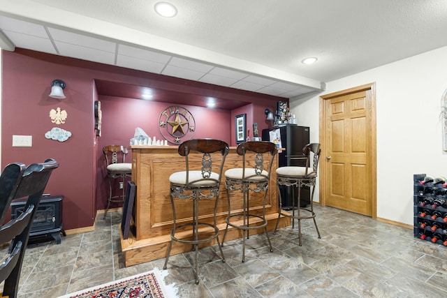 3792 Foxglove Ln, Winnebago, IL 61088 - indoor dry bar with a wood stove, stone finish floors, recessed lighting, and a paneled ceiling