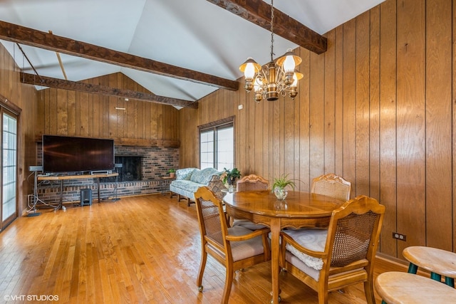 9445 Le Claire Ave, Skokie, IL 60077 - dining space featuring wood walls, light wood-type flooring, a chandelier, and a brick fireplace