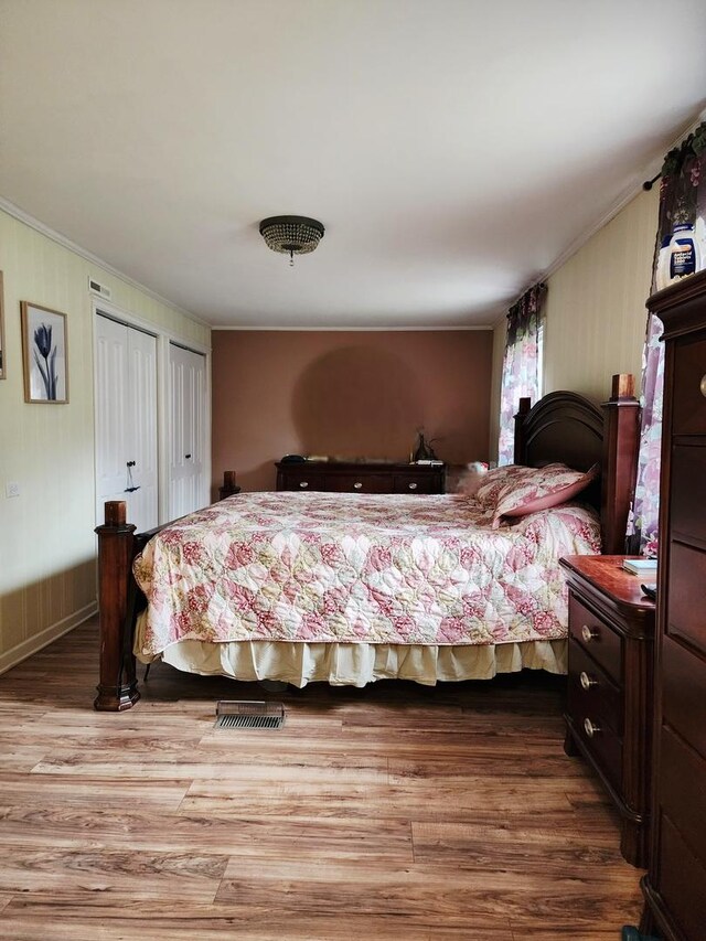 94 E Lakeview Ave, Round Lake Beach, IL 60073 - bedroom featuring crown molding, wood finished floors, and multiple closets