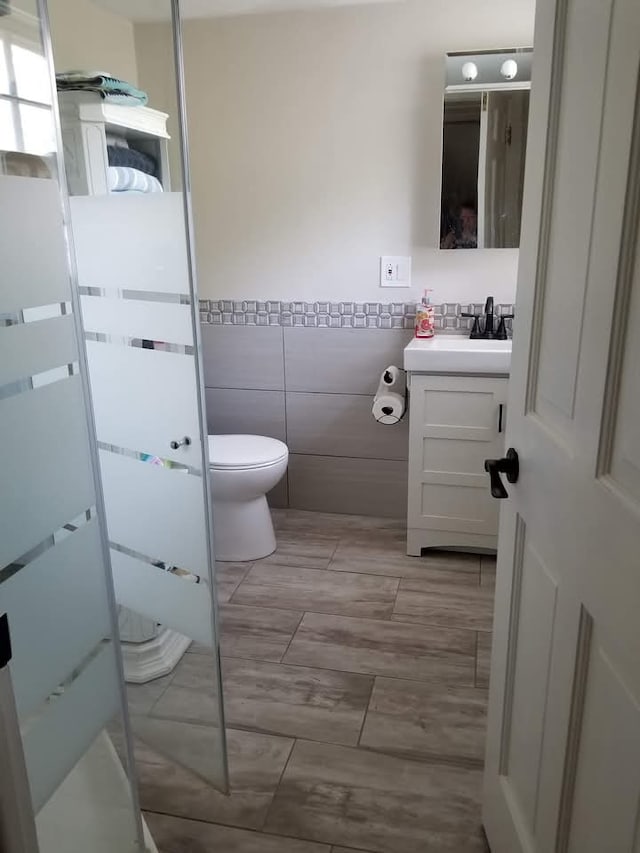 94 E Lakeview Ave, Round Lake Beach, IL 60073 - full bath featuring vanity, tile walls, a stall shower, and a wainscoted wall