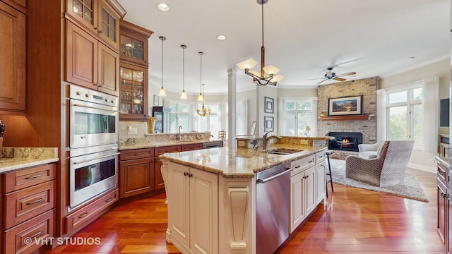 870 Legacy Rdg, Algonquin, IL 60102 - kitchen featuring appliances with stainless steel finishes, a brick fireplace, open floor plan, crown molding, and dark wood finished floors