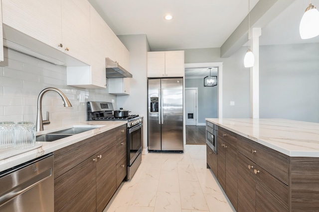 1535 W Estes Ave Unit 4, Chicago, IL 60626 - kitchen with appliances with stainless steel finishes, under cabinet range hood, light marble finish flooring, backsplash, and hanging light fixtures