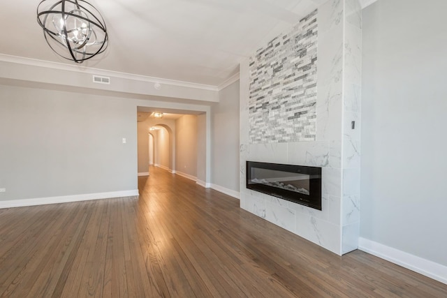 1535 W Estes Ave Unit 4, Chicago, IL 60626 - unfurnished living room featuring arched walkways, a chandelier, wood finished floors, a fireplace, and crown molding