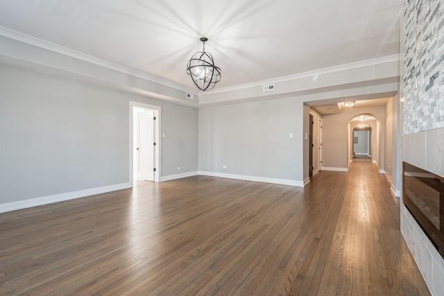 1535 W Estes Ave Unit 4, Chicago, IL 60626 - unfurnished living room with arched walkways, a chandelier, dark wood-style floors, ornamental molding, and a tiled fireplace