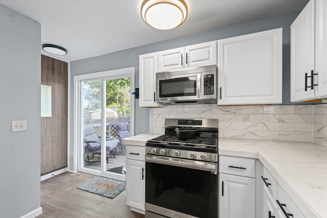 201 N Sycamore St, Villa Grove, IL 61956 - kitchen with appliances with stainless steel finishes, light countertops, tasteful backsplash, and white cabinets