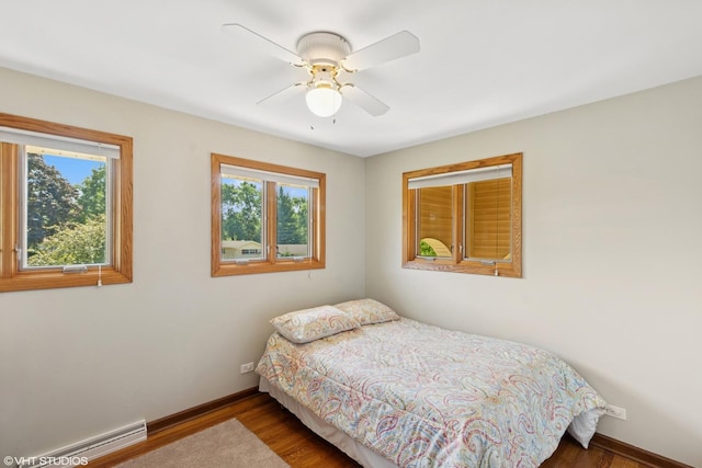 1142 N Perry Dr, Palatine, IL 60067 - bedroom with a baseboard heating unit, wood finished floors, and ceiling fan