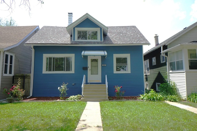 2524 N Mont Clare Ave, Chicago, IL 60707 - bungalow featuring a front yard, entry steps, a shingled roof, and a chimney