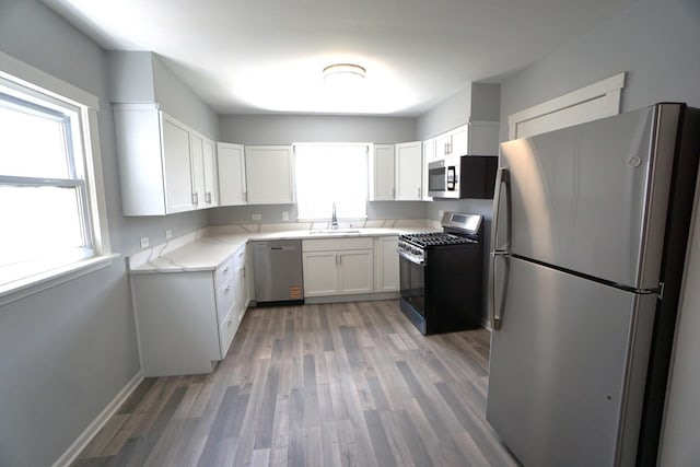 2524 N Mont Clare Ave, Chicago, IL 60707 - kitchen with stainless steel appliances, light wood-type flooring, light stone counters, and white cabinets