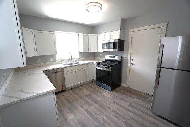 2524 N Mont Clare Ave, Chicago, IL 60707 - kitchen with stainless steel appliances, light wood-type flooring, light stone counters, and white cabinetry