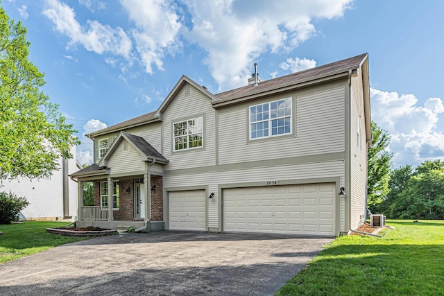 2054 S Jonathan Dr, Round Lake, IL 60073 - traditional-style home featuring an attached garage, driveway, a front yard, and a porch