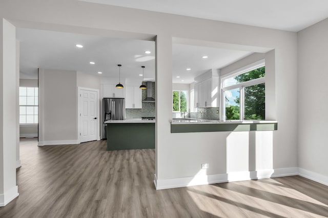 2054 S Jonathan Dr, Round Lake, IL 60073 - kitchen with stainless steel fridge with ice dispenser, white cabinets, wood finished floors, light countertops, and backsplash