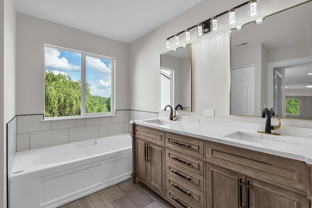 2054 S Jonathan Dr, Round Lake, IL 60073 - full bathroom featuring double vanity, plenty of natural light, a bath, and wood finished floors
