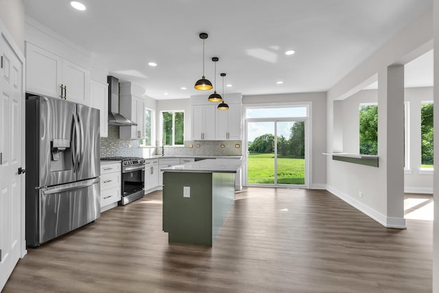 2054 S Jonathan Dr, Round Lake, IL 60073 - kitchen featuring stainless steel appliances, wall chimney exhaust hood, tasteful backsplash, white cabinets, and dark wood-style floors