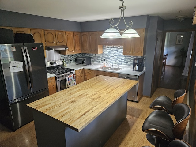 811 N Glenwood Pl, Aurora, IL 60506 - kitchen featuring stainless steel appliances, butcher block countertops, light wood-style floors, and under cabinet range hood