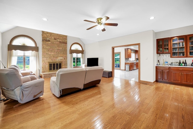 1816 Princeton Rd, Flossmoor, IL 60422 - living area featuring lofted ceiling, a ceiling fan, light wood-type flooring, bar with sink, and a stone fireplace