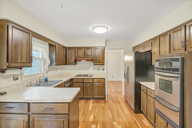 1016 Charleston Dr, Saint Charles, IL 60174 - kitchen featuring appliances with stainless steel finishes, a warming drawer, light wood-style flooring, light countertops, and under cabinet range hood