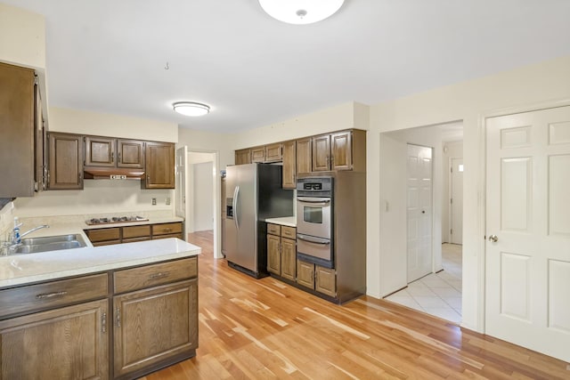 1016 Charleston Dr, Saint Charles, IL 60174 - kitchen with appliances with stainless steel finishes, a warming drawer, light countertops, light wood finished floors, and under cabinet range hood