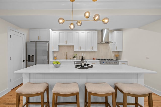 4250 N Whipple St, Chicago, IL 60618 - kitchen featuring wall chimney range hood, stainless steel fridge, range, an island with sink, and backsplash