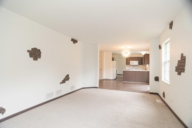 10 Sugar Creek Ct, Lake In The Hills, IL 60156 - unfurnished living room with dark colored carpet and a chandelier