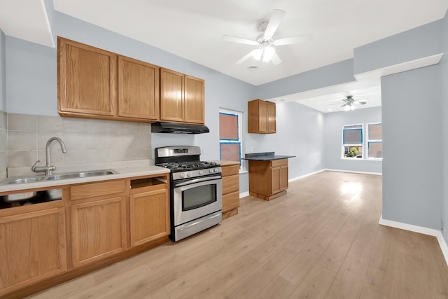 3826 S Honore St, Chicago, IL 60609 - kitchen featuring stainless steel range with gas cooktop, under cabinet range hood, a ceiling fan, backsplash, and light wood-style floors