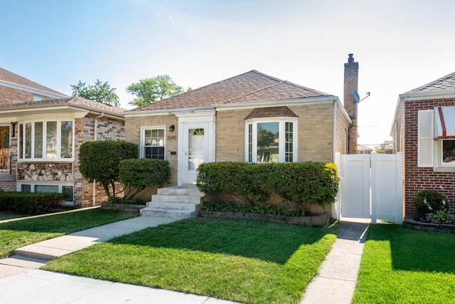 3345 N Page Ave, Chicago, IL 60634 - view of front of house featuring brick siding, a chimney, a shingled roof, and a gate