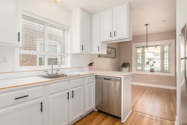 3345 N Page Ave, Chicago, IL 60634 - kitchen featuring dishwasher, light wood finished floors, white cabinetry, light countertops, and pendant lighting
