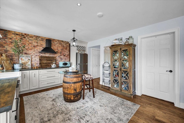 6 Barbados Ct N, Putnam, IL 61560 - interior space featuring freestanding refrigerator, wall chimney range hood, dark wood finished floors, pendant lighting, and butcher block countertops
