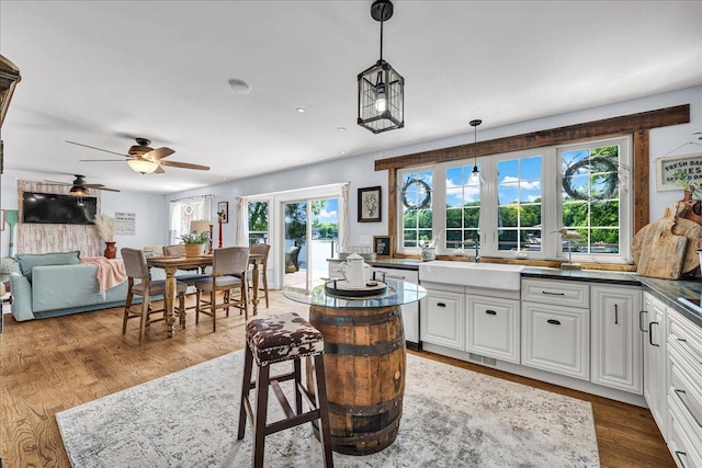 6 Barbados Ct N, Putnam, IL 61560 - kitchen featuring a ceiling fan, pendant lighting, dark countertops, wood finished floors, and white cabinetry