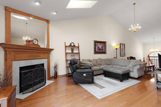7672 Thistlewood Ln, Frankfort, IL 60423 - living room with a chandelier, lofted ceiling, light wood finished floors, a fireplace, and a skylight