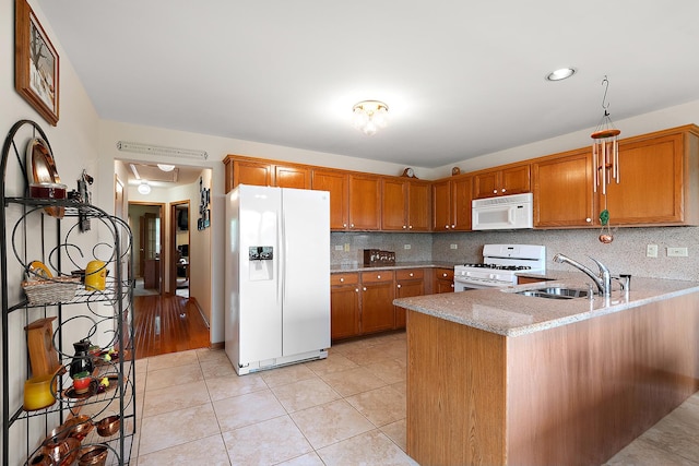 7672 Thistlewood Ln, Frankfort, IL 60423 - kitchen featuring white appliances, brown cabinetry, decorative backsplash, a peninsula, and recessed lighting