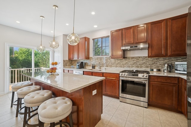 234 Cassidy Ln, Elgin, IL 60124 - kitchen with stainless steel gas range, tasteful backsplash, light tile patterned floors, under cabinet range hood, and a breakfast bar area
